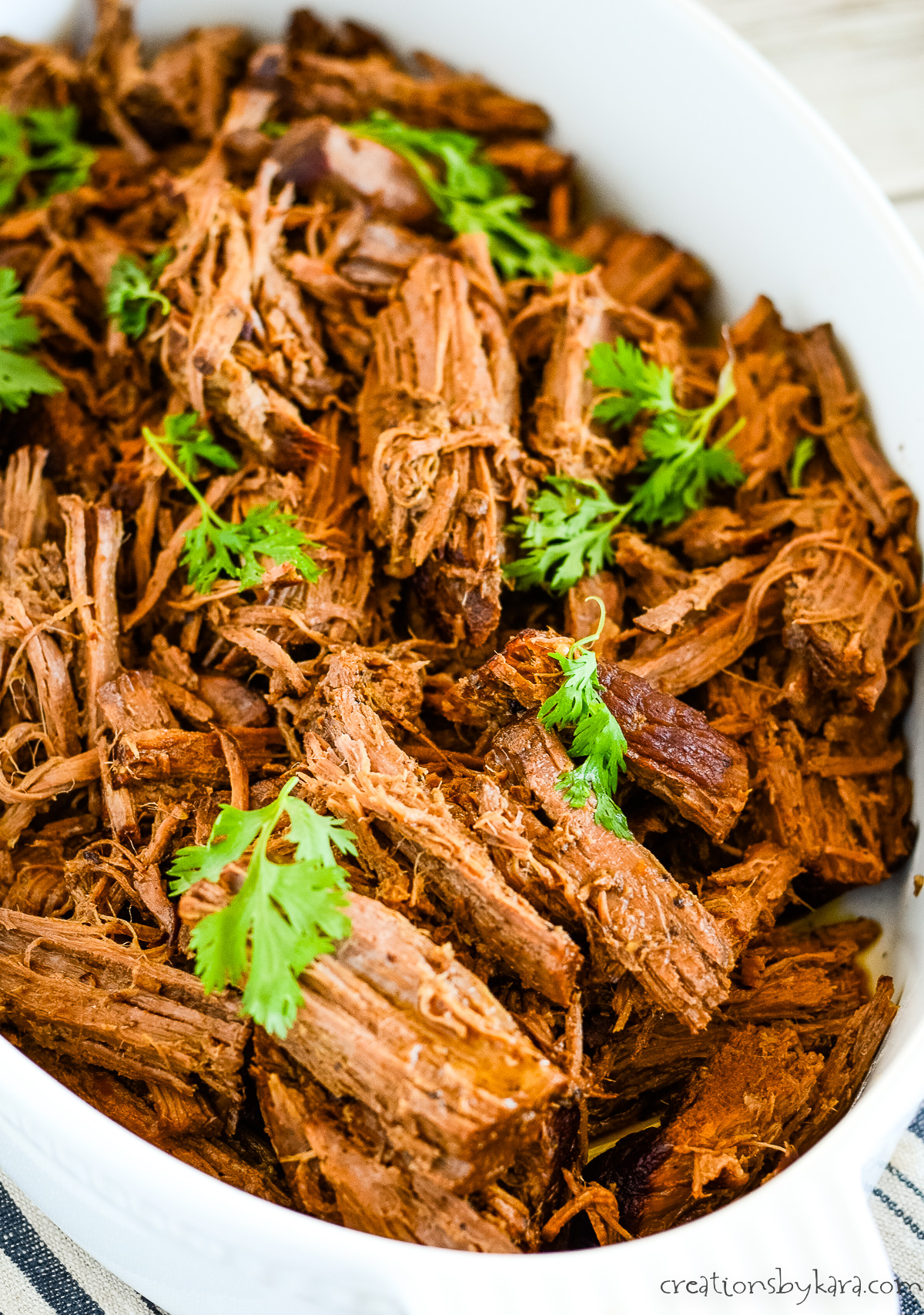 dish of shredded balsamic pot roast garnished with parsley