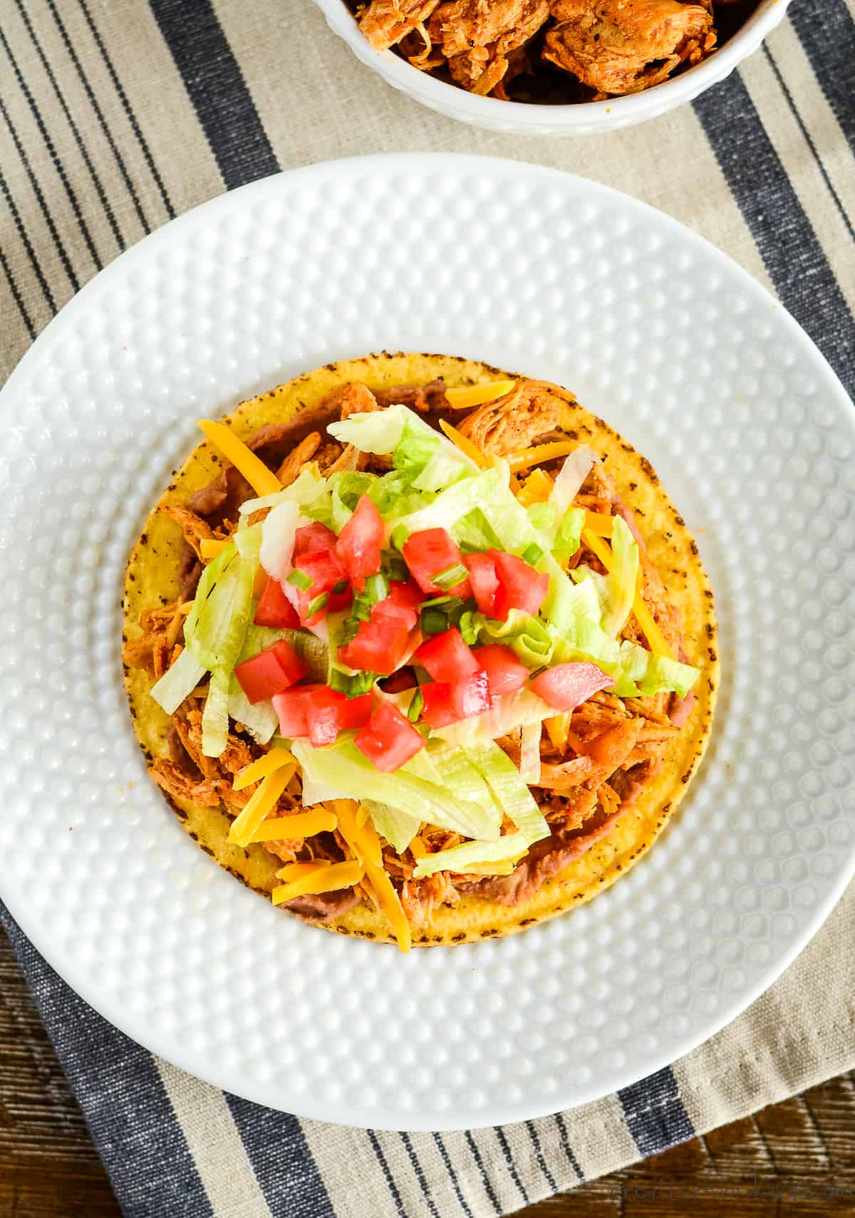overhead shot of shredded chicken tostada with all the fixings