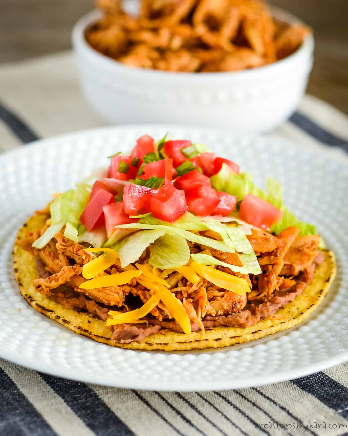 tostada with shredded chicken and refried beans