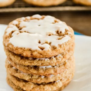 stack of iced oatmeal cookies on a white plate