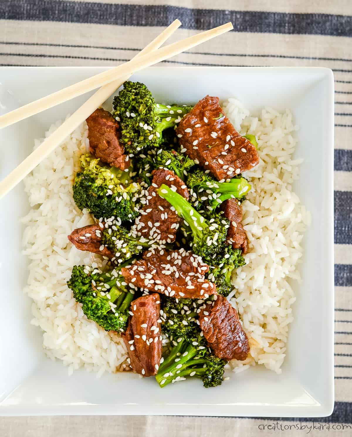 overhead shot of rice with broccoli & beef garnished with sesame seeds