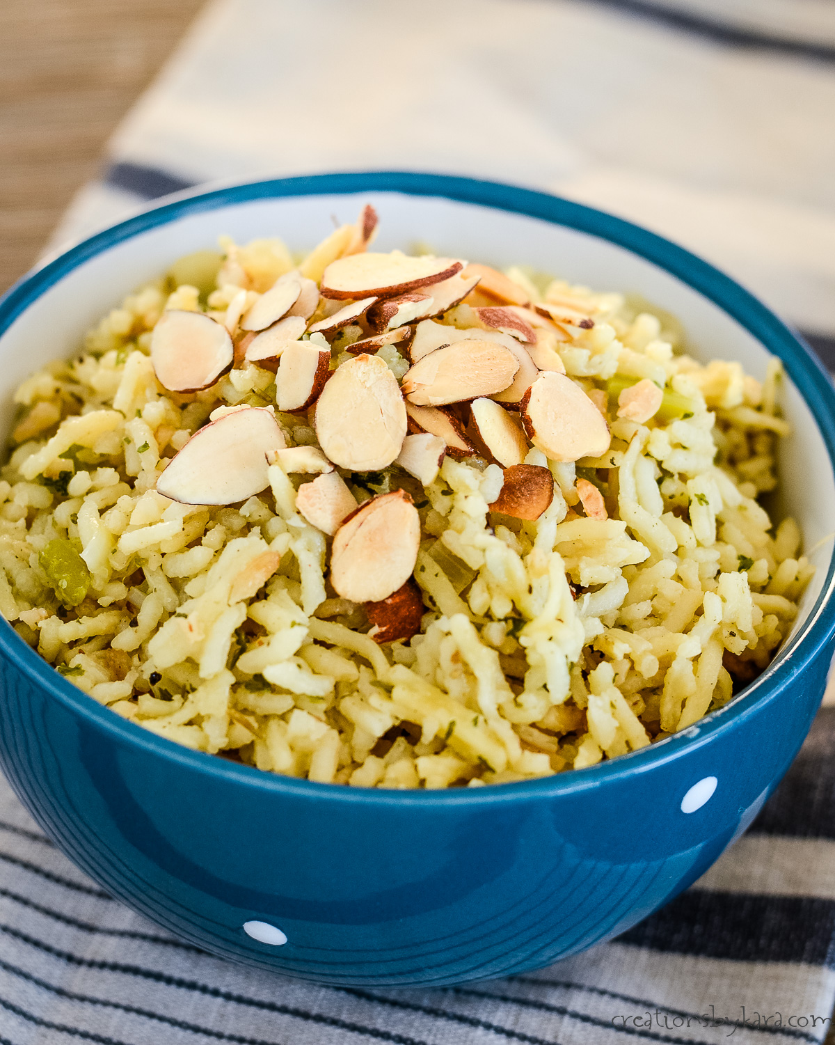 homemade rice pilaf sprinkled with sliced almonds in a blue bowl