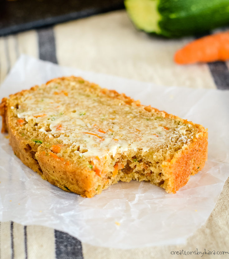 slice of carrot zucchini bread with a bite taken out of it on a piece of waxed paper
