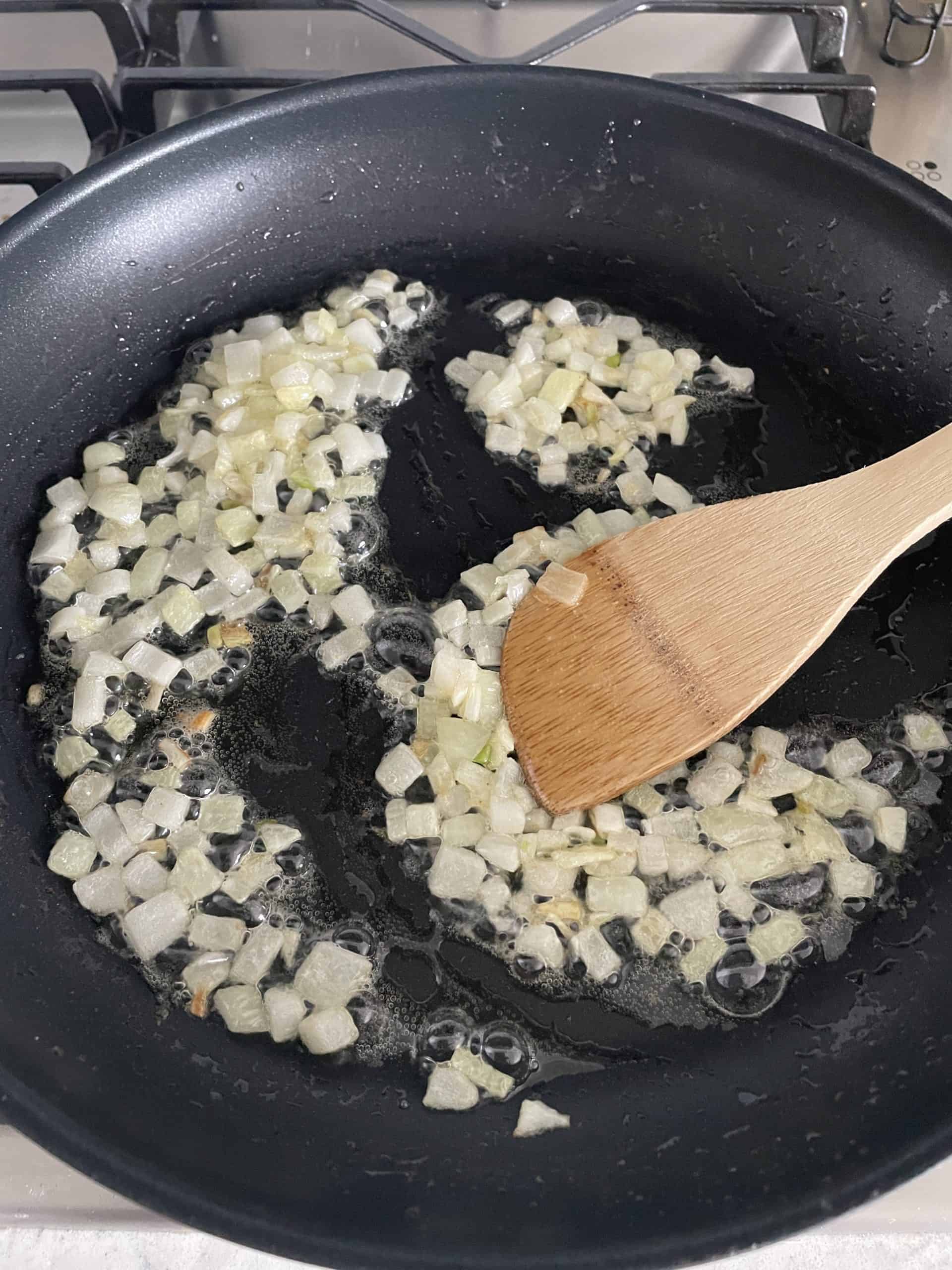 diced onions and butter sauteing in a skillet