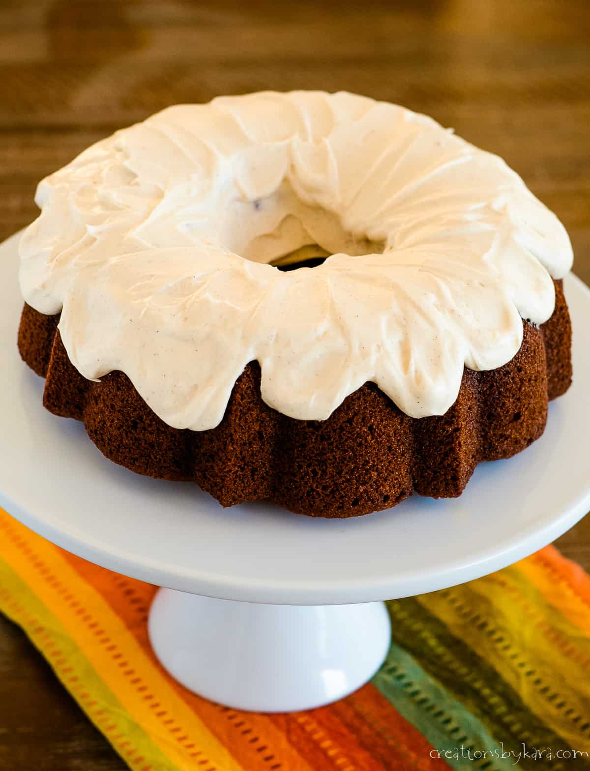 frosted pumpkin bundt cake on a cake stand