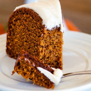 bite of pumpkin cake on a fork on a plate with a slice of cake
