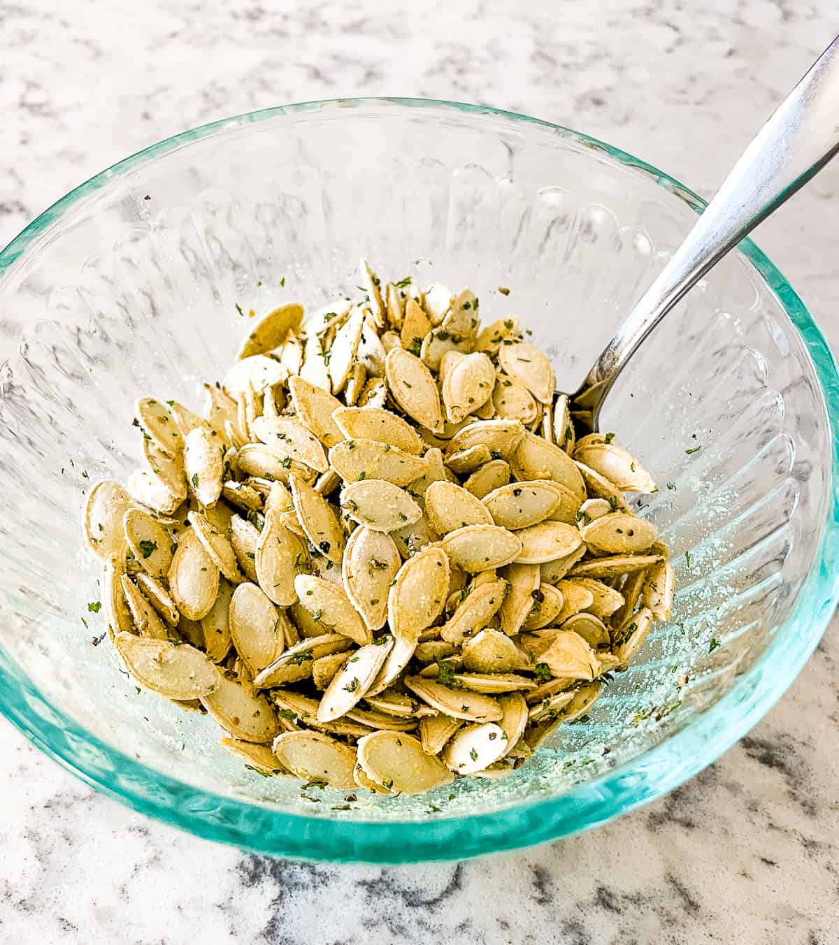 bowl of raw pumpkin seeds with seasoning