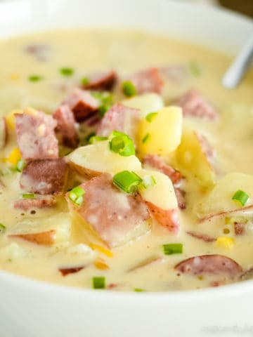 bowl of smoked sausage soup with a spoon in it