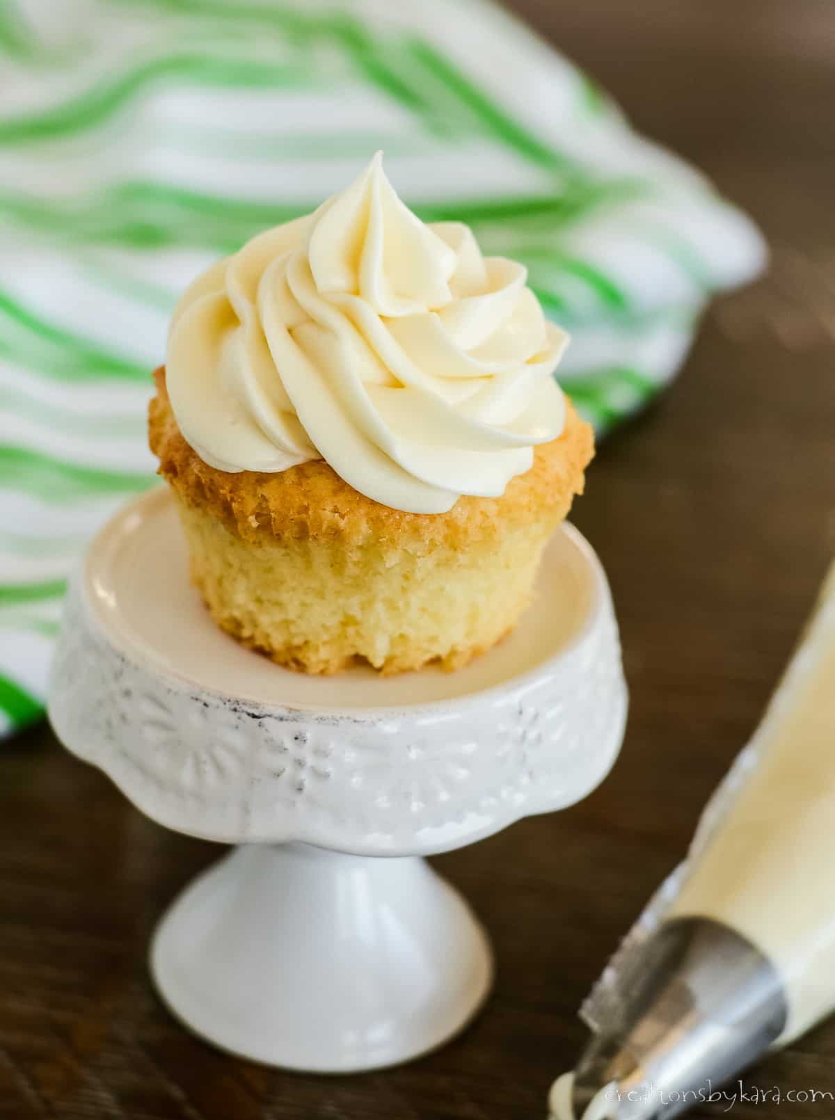 cupcake with butter cream cheese frosting on a cupcake stand