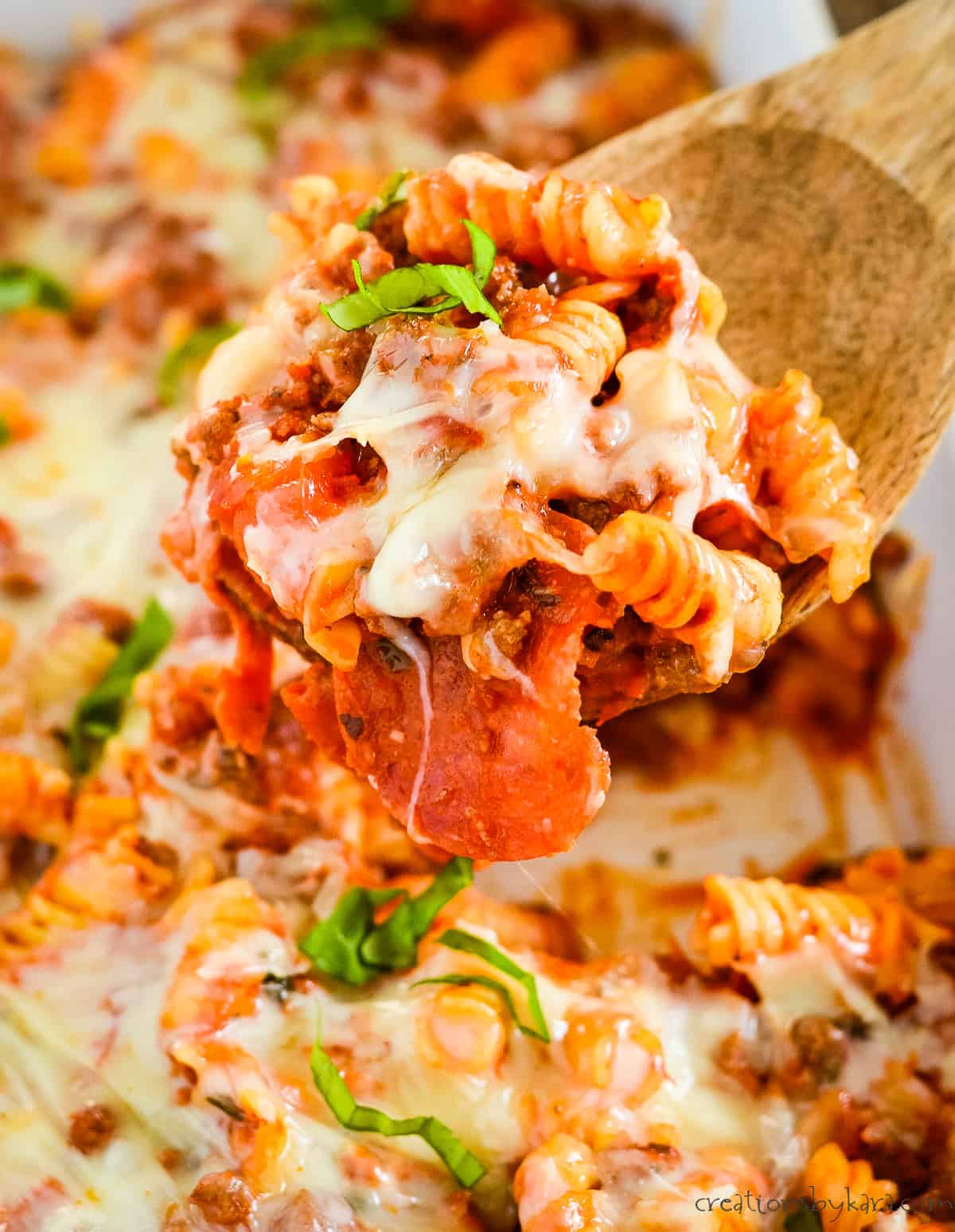 pizza casserole with melted cheese, garnished with fresh basil