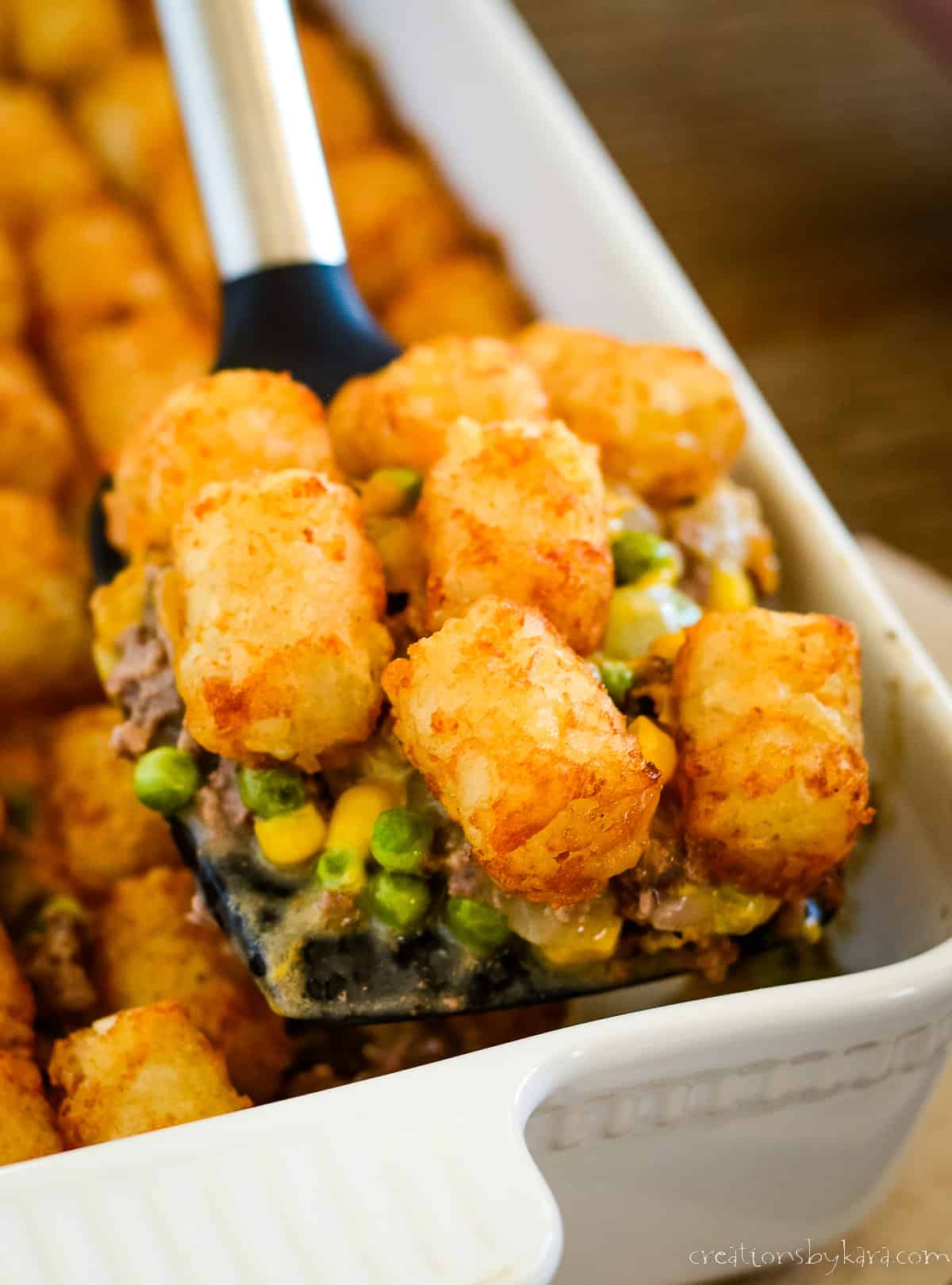 scoop of tater tot casserole with corn and peas