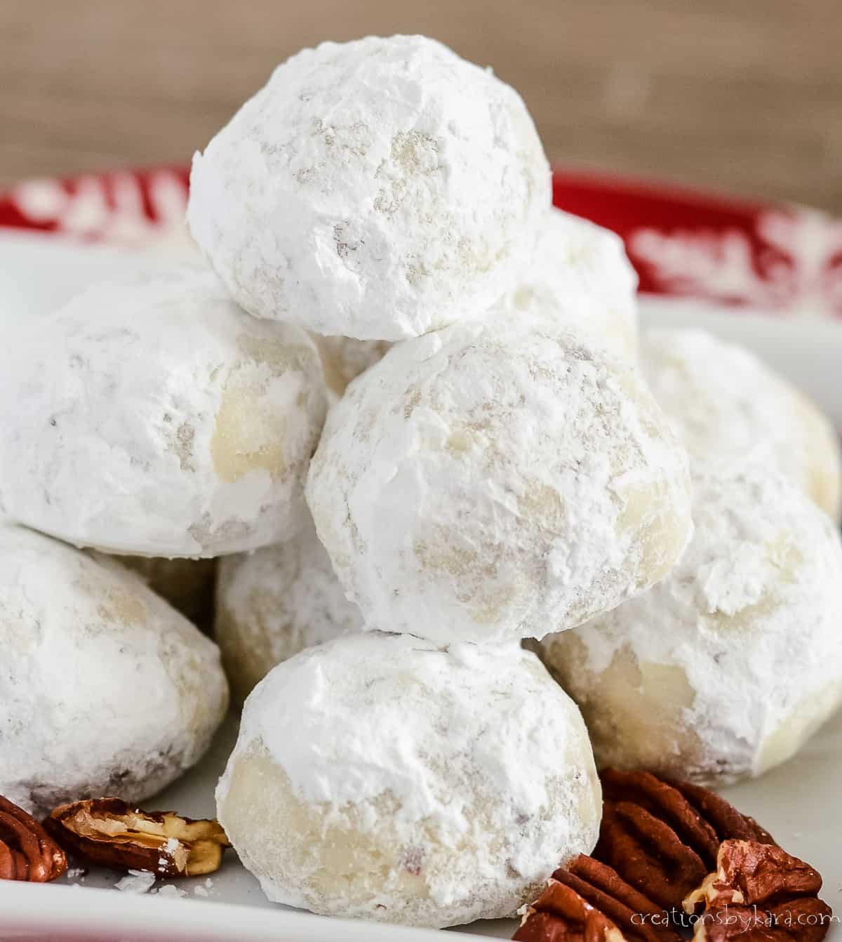 pile of danish wedding cookies on a white and red plate 