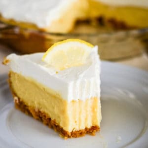 slice of creamy lemon pie with graham cracker crust and whipped cream