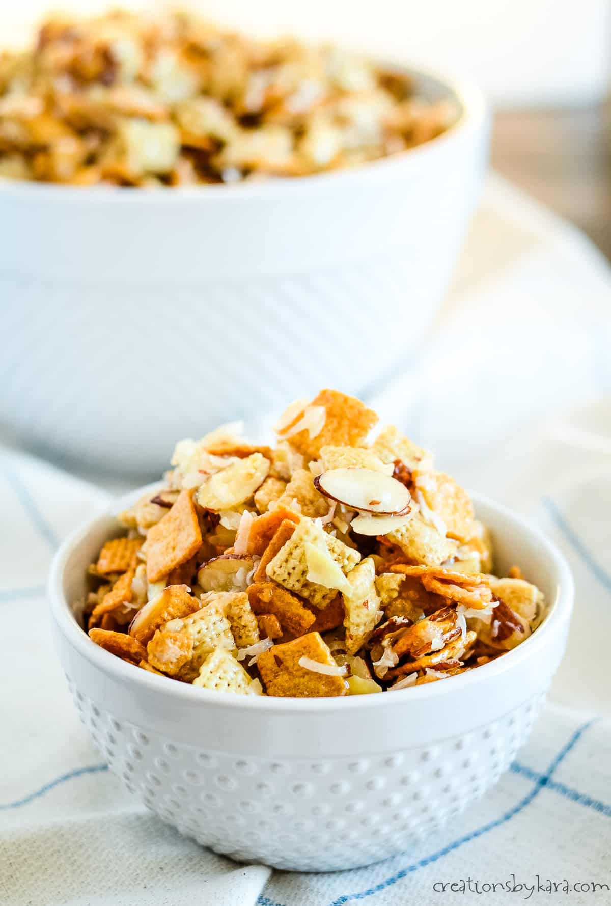 small bowl of sweet chex mix with a large bowl in the background