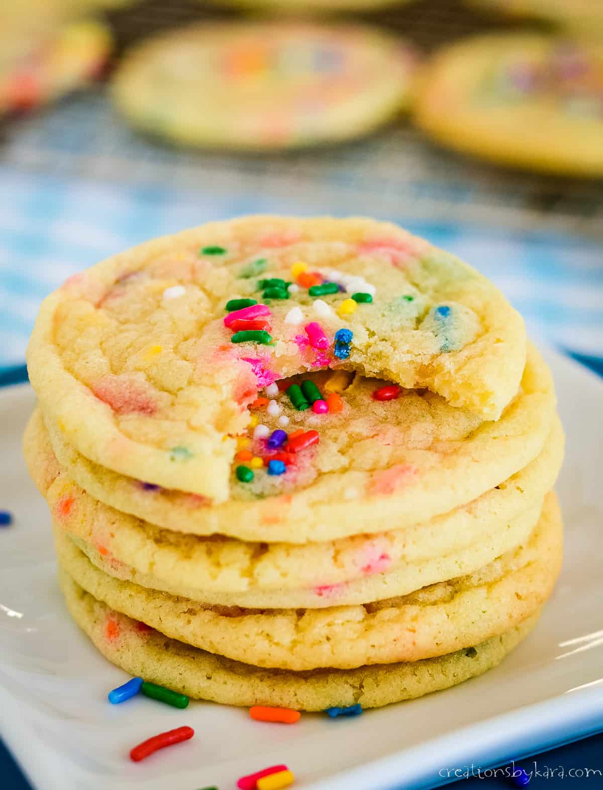 stack of funfetti cookies, one with a bite taken out of it