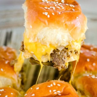 cheeseburger slider being pulled from the pan
