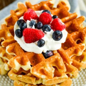 plate of sourdough waffles with whipped cream and fresh berries