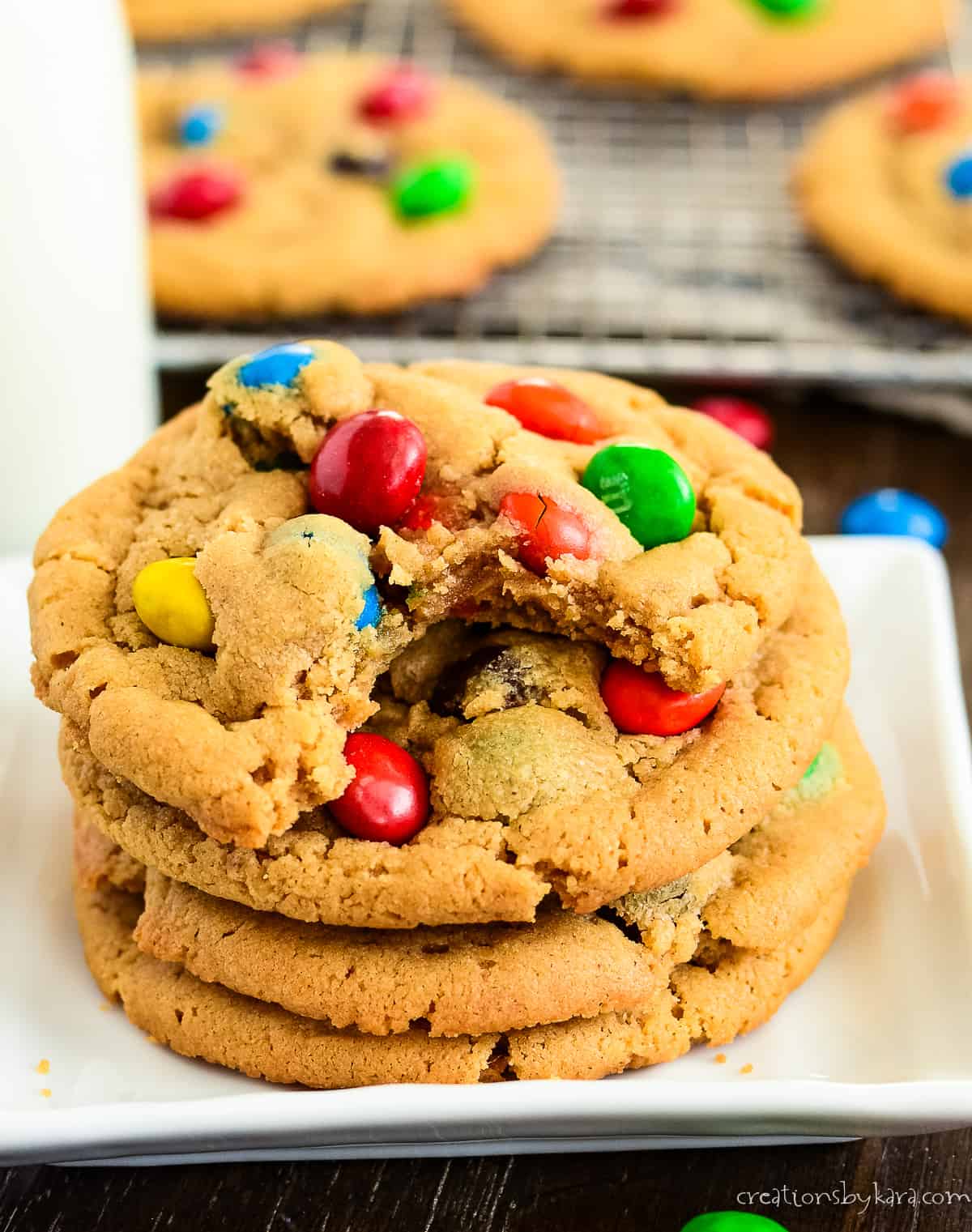peanut m&m cookie recipe photo - cookies stacked on a white plate