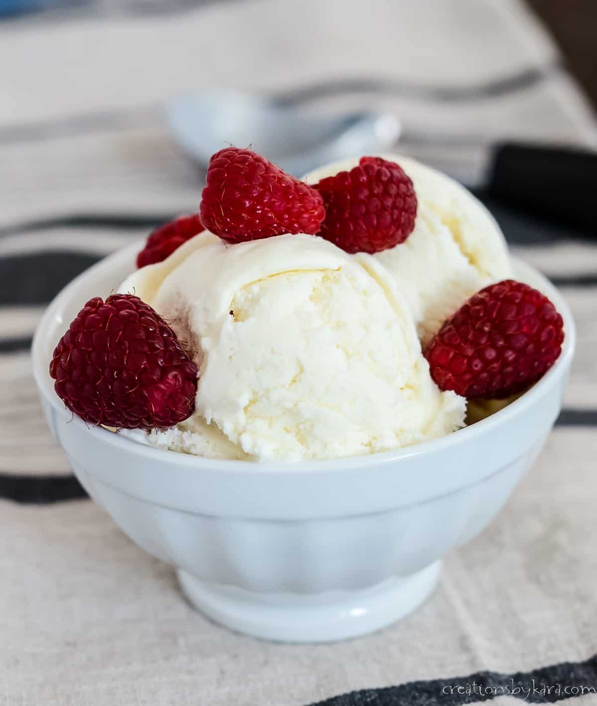 bowl of egg free vanilla ice cream with raspberries
