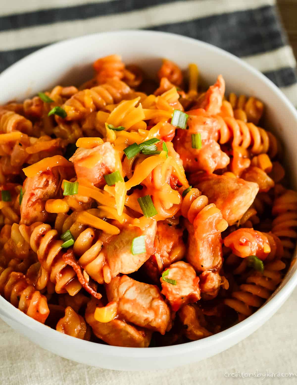 bowl of bbq chicken pasta topped with cheese