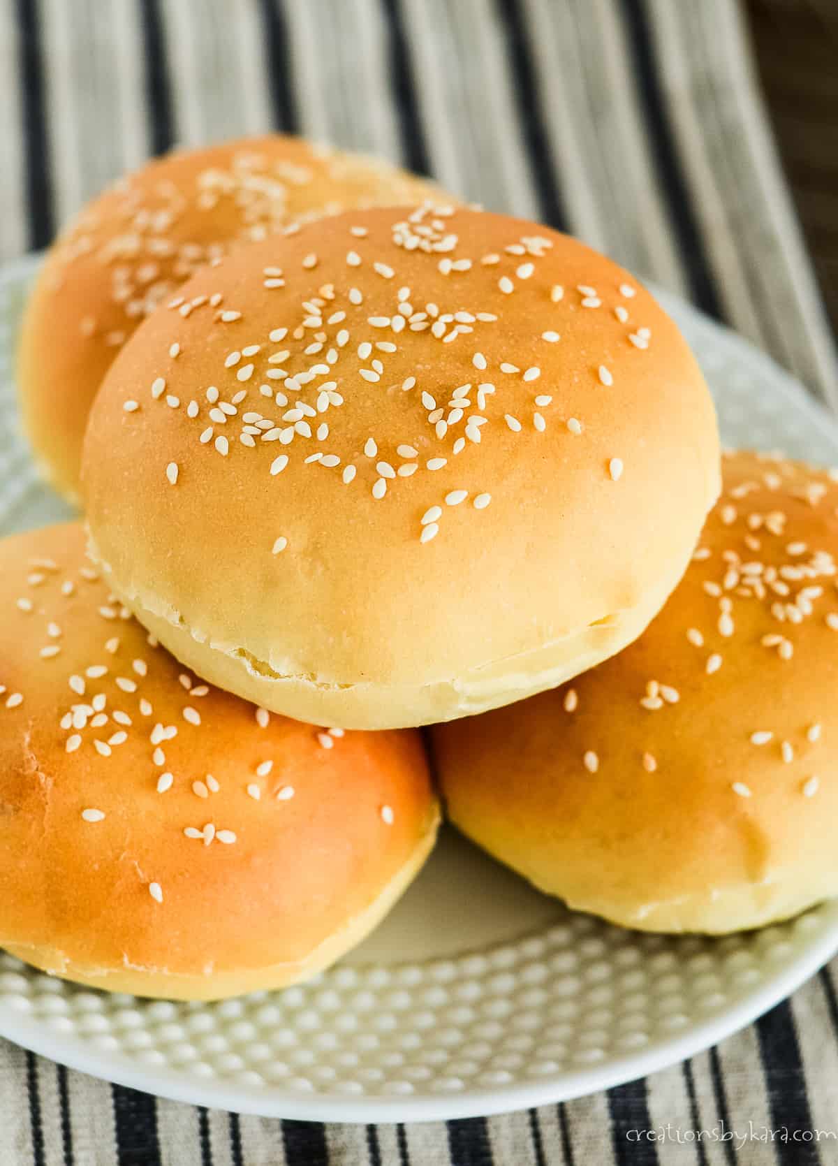 plate of soft homemade hamburger buns with sesame seeds