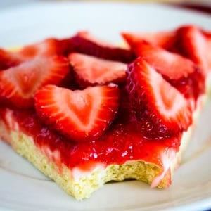 slice of strawberry pizza with a bite taken out of it