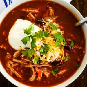 bowl of instant pot pork chili with cheese and sour cream