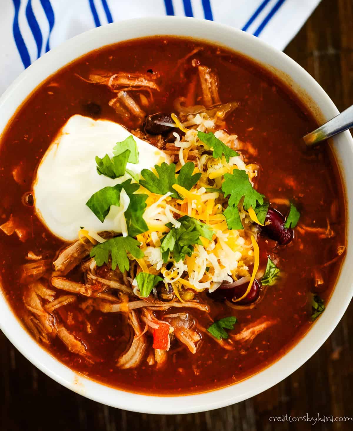bowl of instant pot pork chili with cheese and sour cream