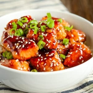bowl of homemade general tso's chicken garnished with green onions