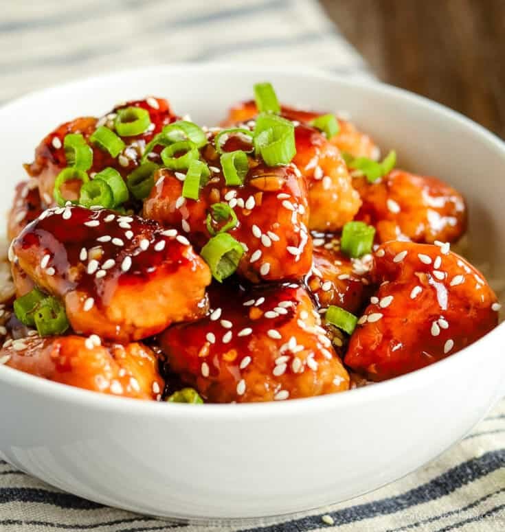 bowl of homemade general tso's chicken garnished with green onions