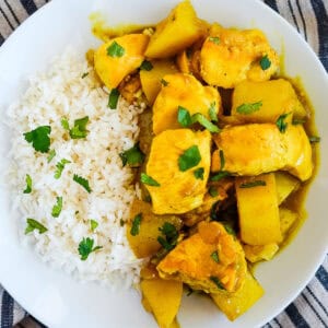 bowl of curry chicken with potatoes and rice