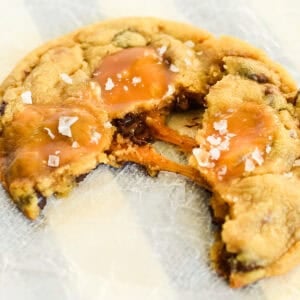 warm salted caramel chocolate chip cookie being pulled apart