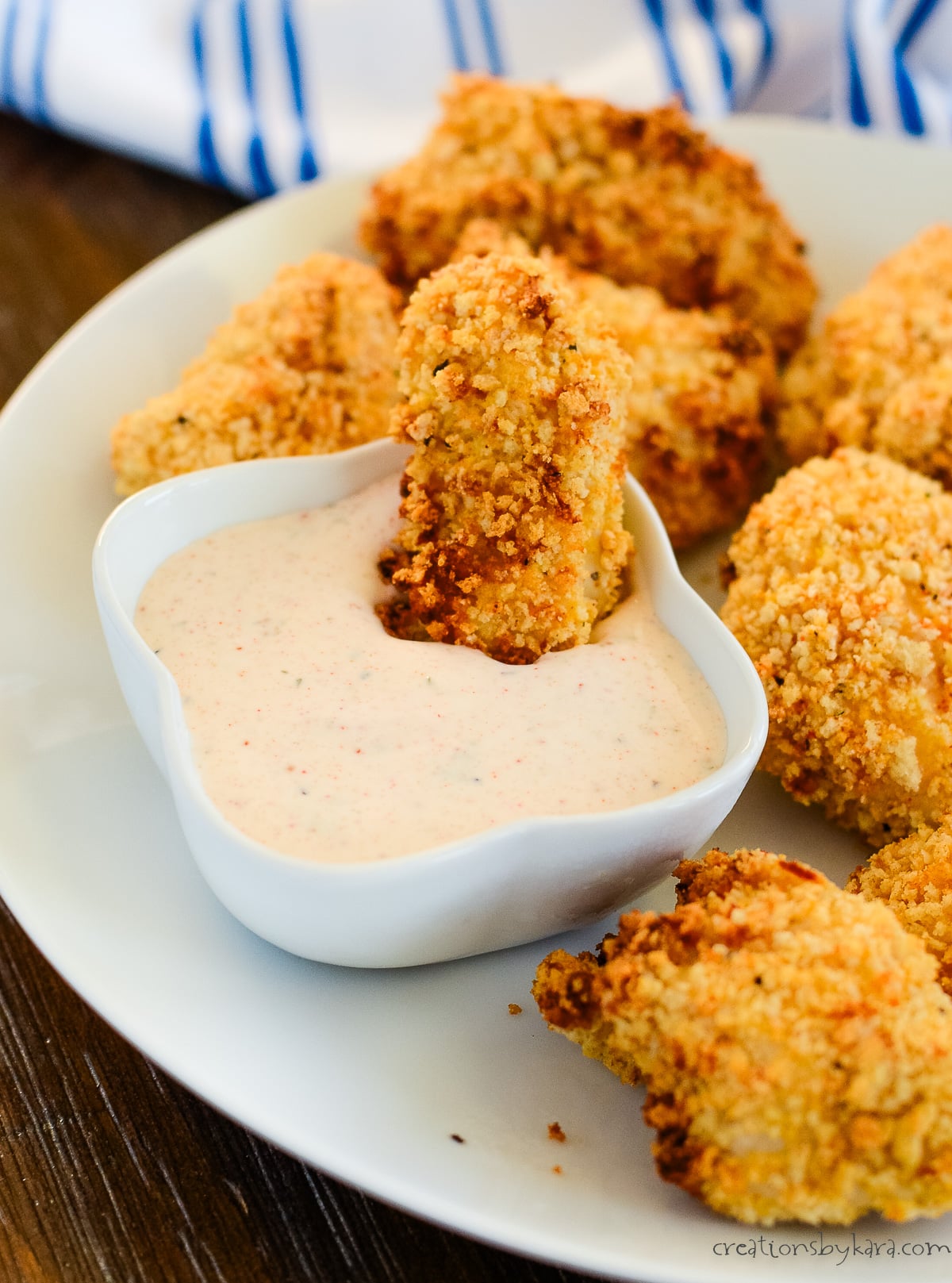 spicy chicken nugget being dipped in spicy ranch