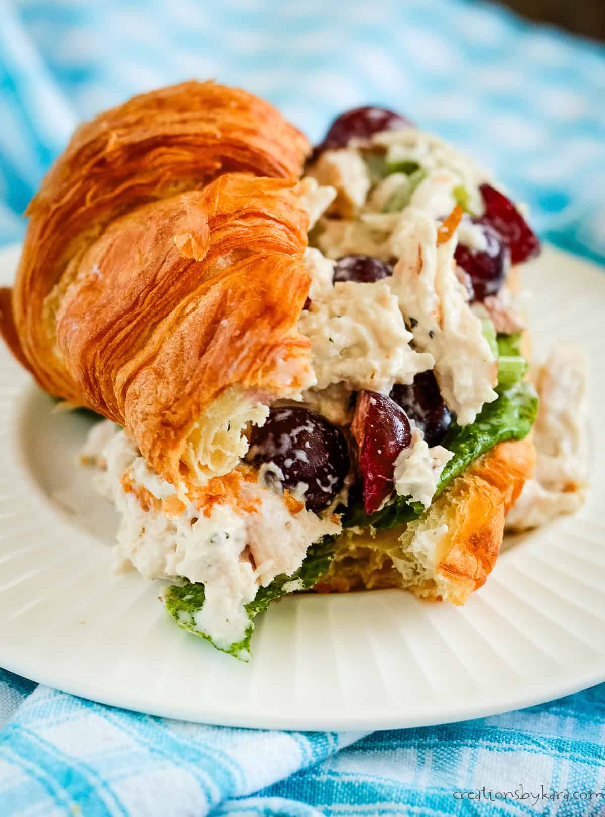 chicken salad croissant sandwich with a bite taken out of it