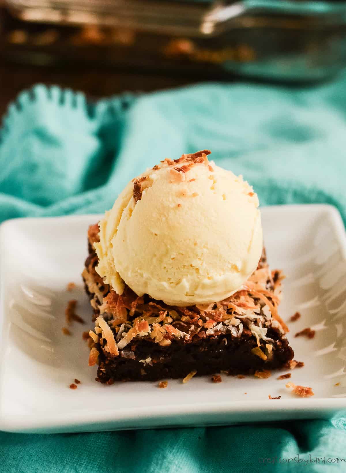 coconut oil brownie on a plate with a scoop of vanilla ice cream