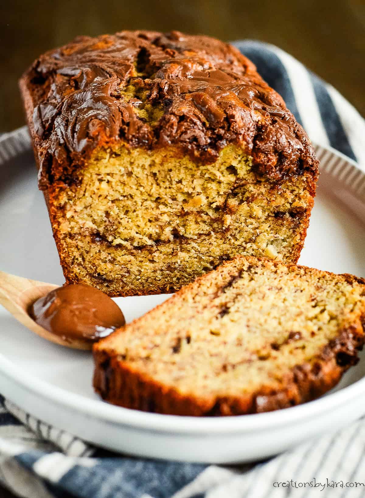 loaf of sliced banana bread with nutella on a white serving platter