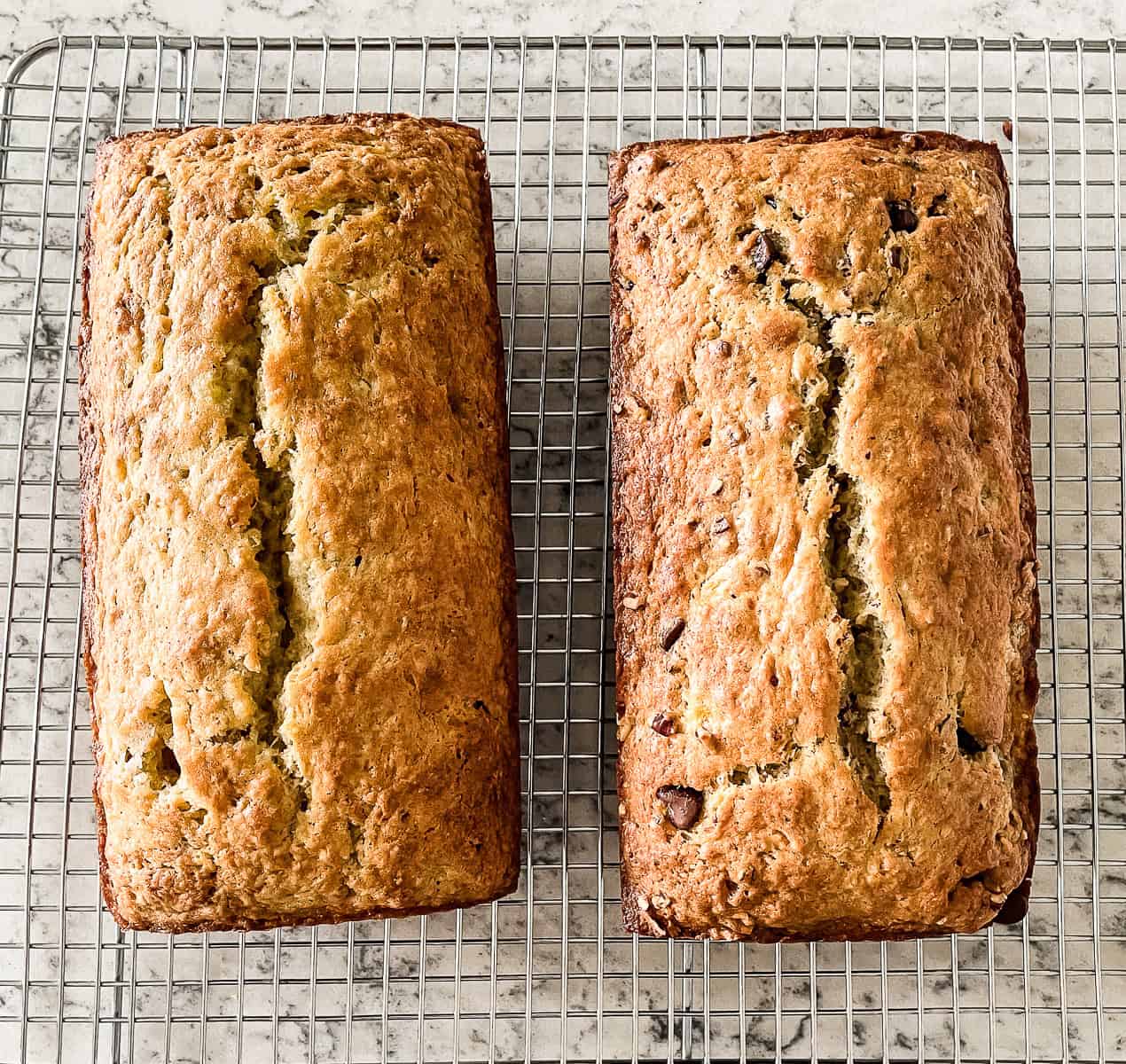 two loaves of sourdough discard banana bread on a wire rack