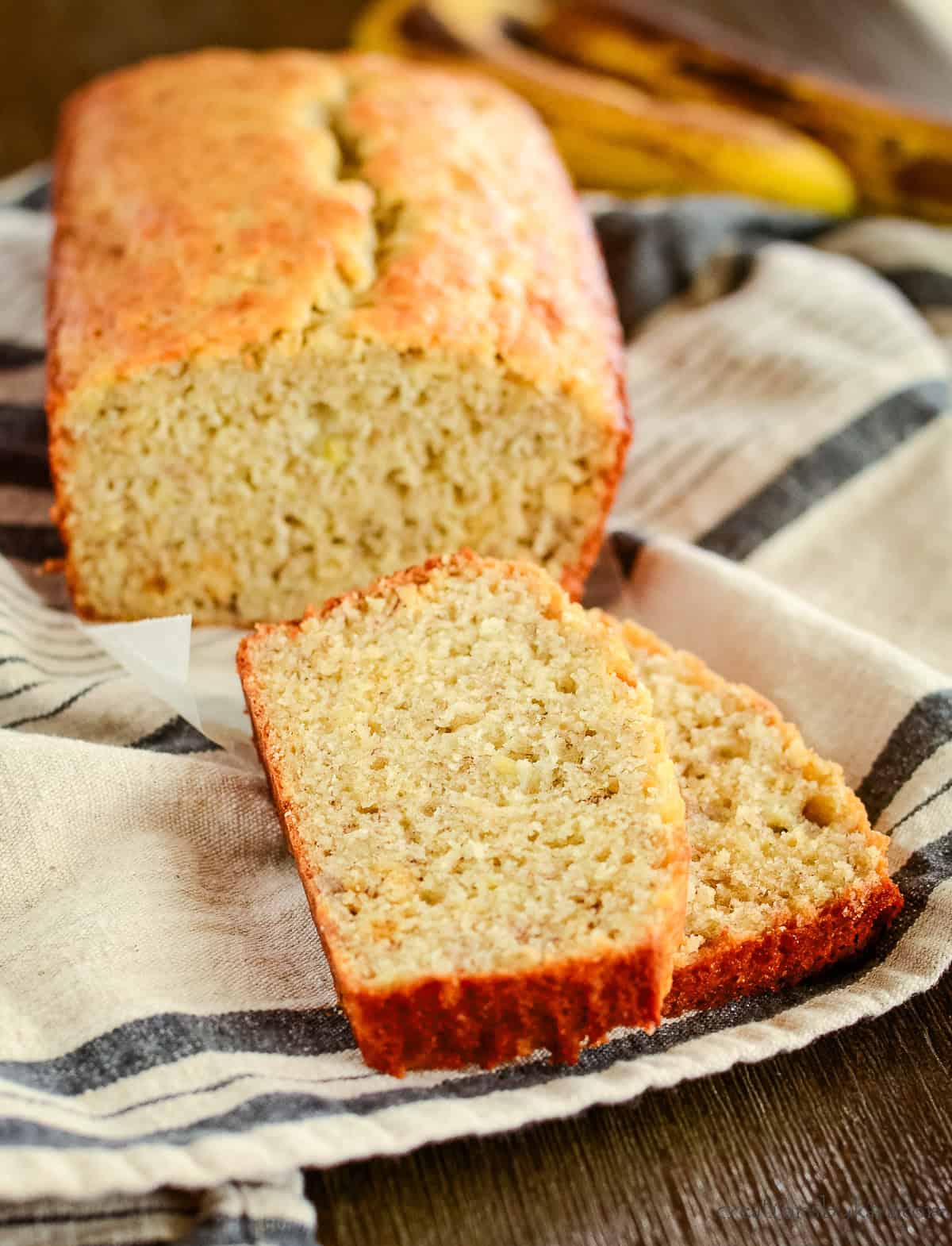 cut loaf of sourdough banana bread with a couple slices in front of it