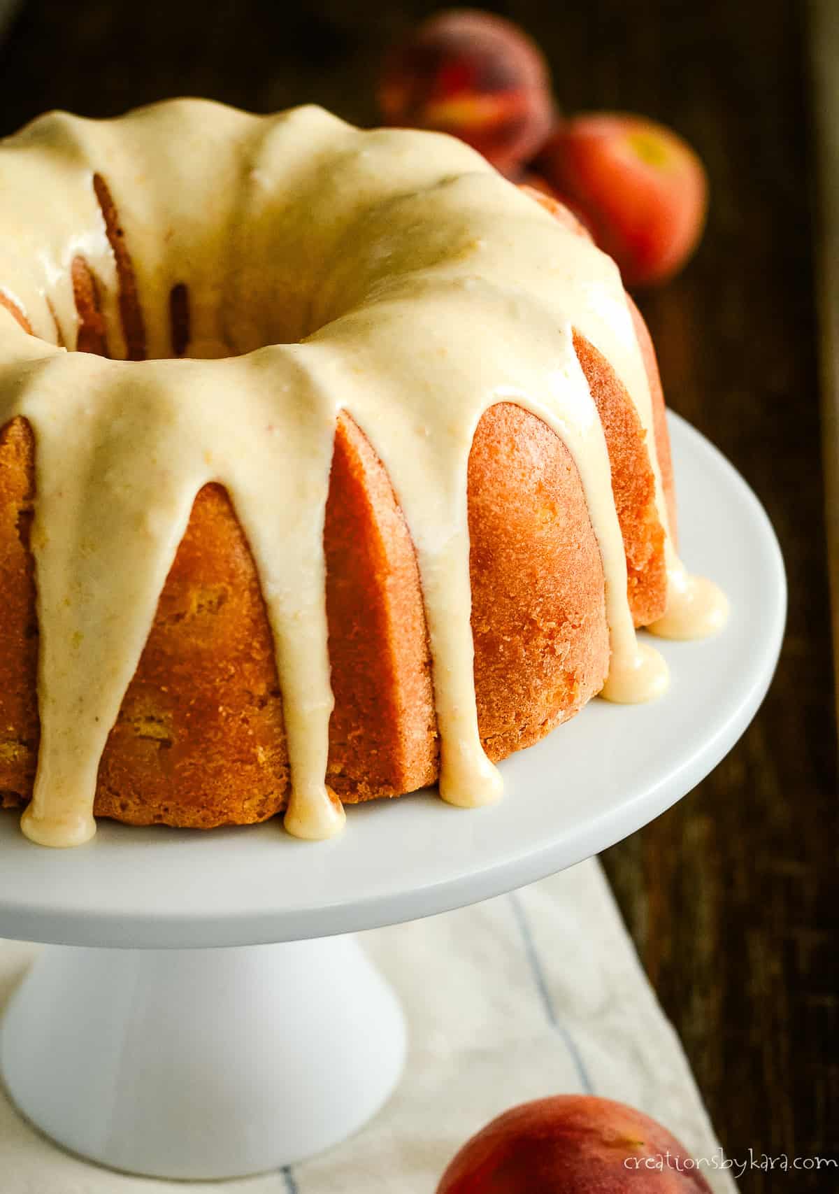 peach bundt cake on a white cake stand