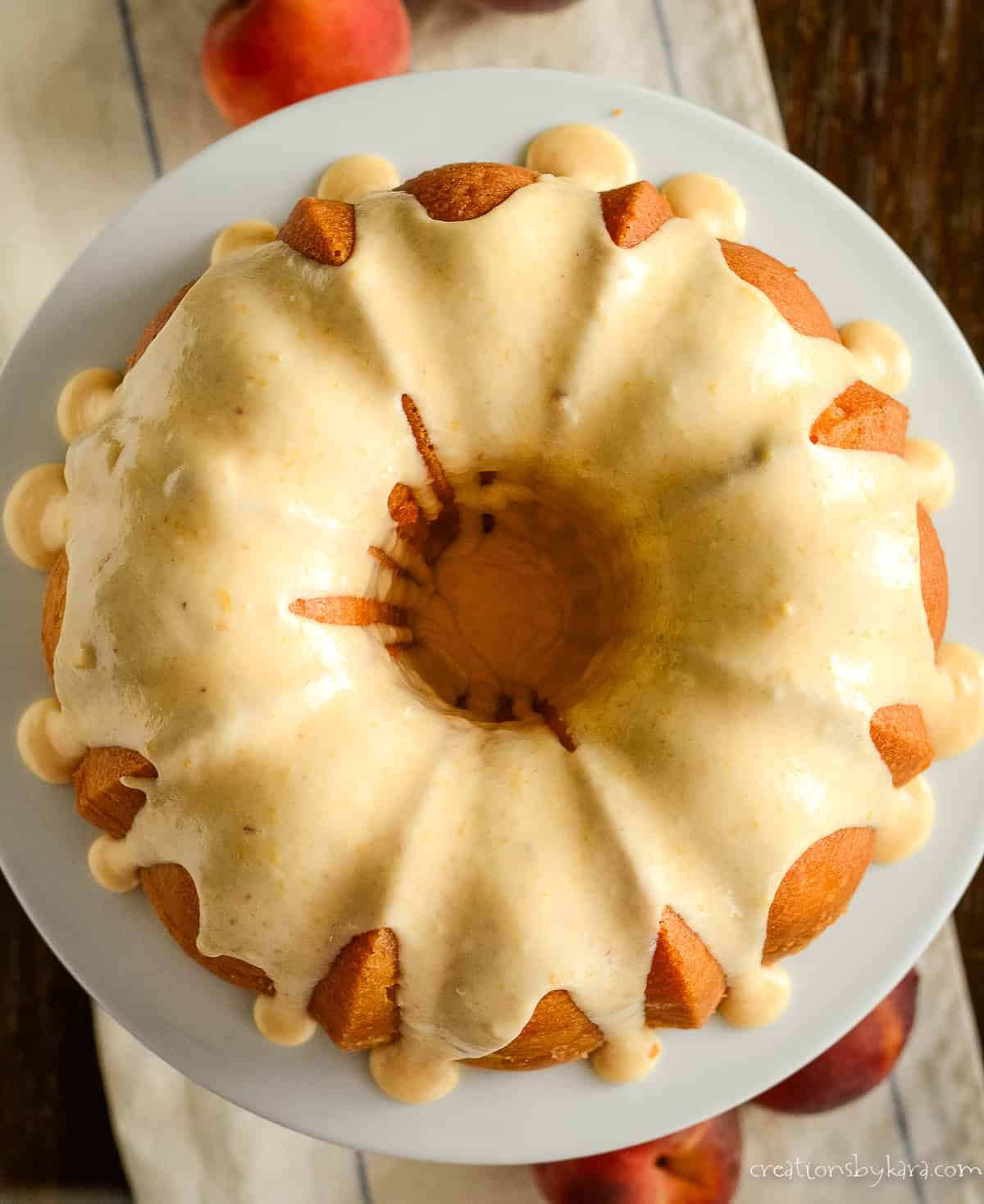 overhead shot of peach bundt cake with peach icing running down the sides