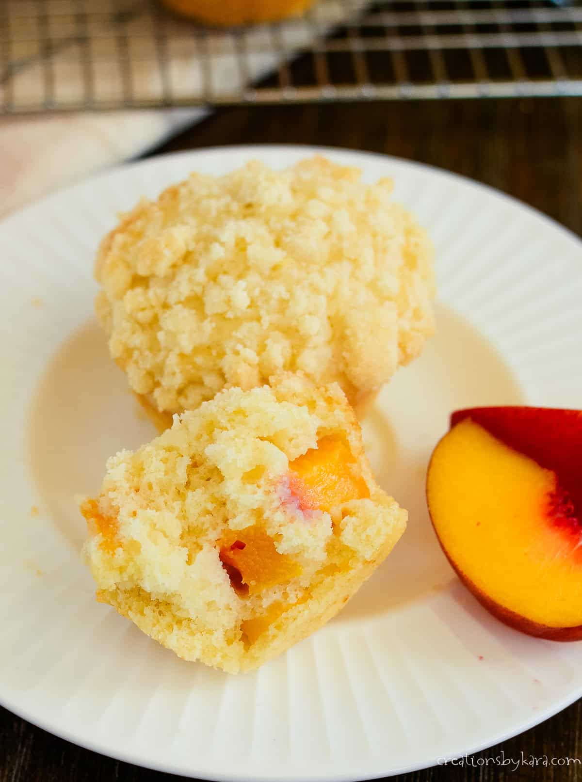 plate with peach streusel muffin broken in half