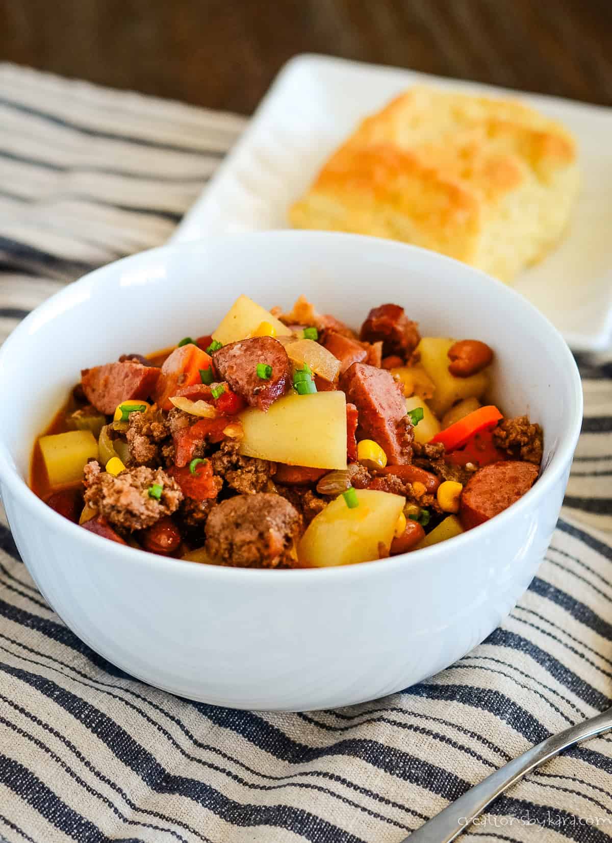 bowl of cowboy stew with a biscuit in the background