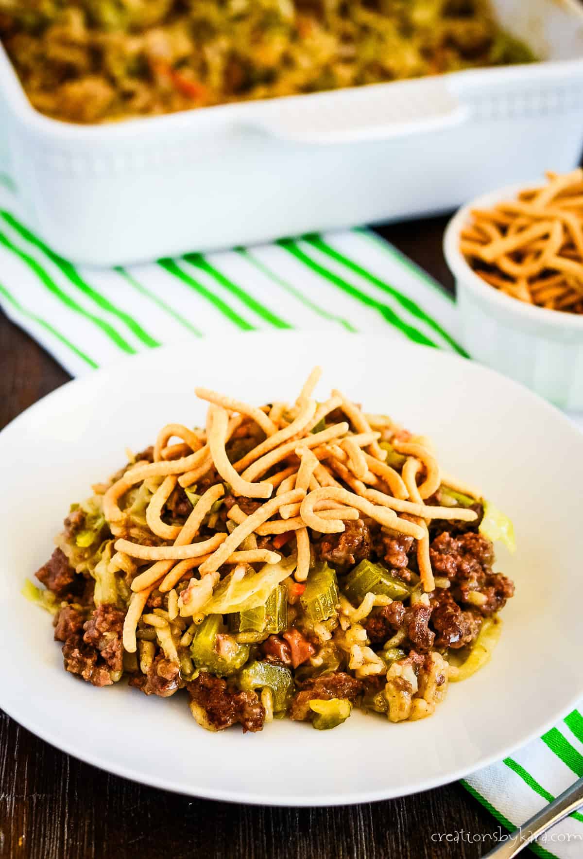 plate of hamburger chow mein with a casserole dish in the background