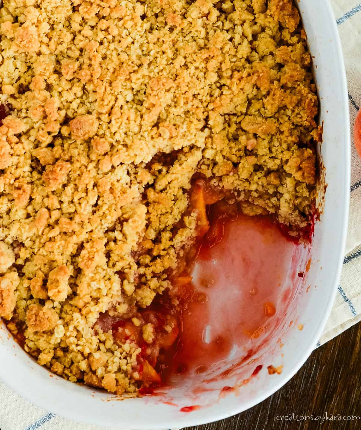 pan of peach raspberry crisp with a scoop taken out