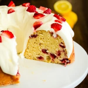 sliced strawberry lemonade pound cake on a white cake stand