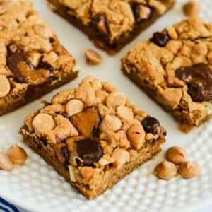 loaded peanut butter blondies on a plate with peanut butter chips